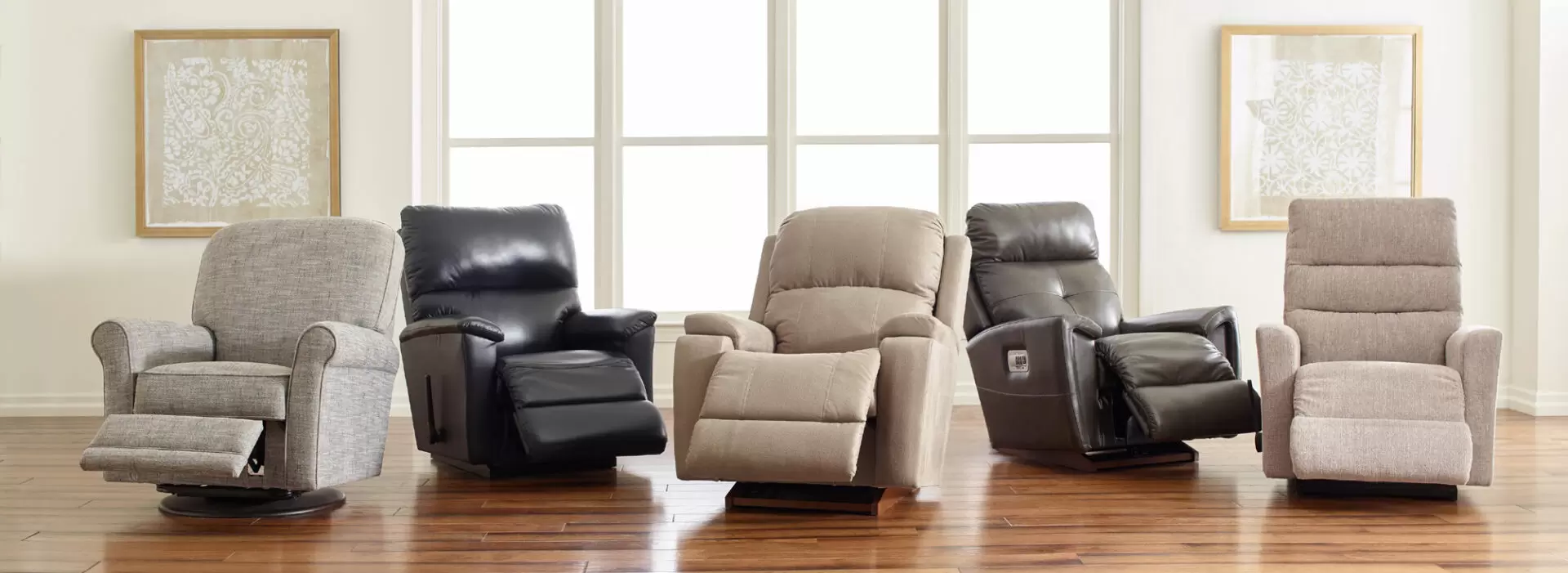 Row of five different stylish recliners in a bright room.